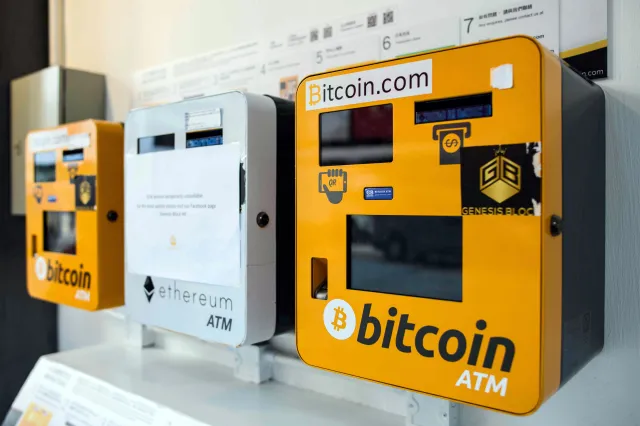 A line of yellow and white physical Bitcoin ATMs and an Ethereum ATM on a wall, capturing the feeling of Bitcoin nostalgia when crypto started appearing in everyday spaces.